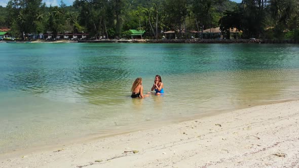 Girls tan on paradise lagoon beach lifestyle by blue water and white sandy background of Thailand ne