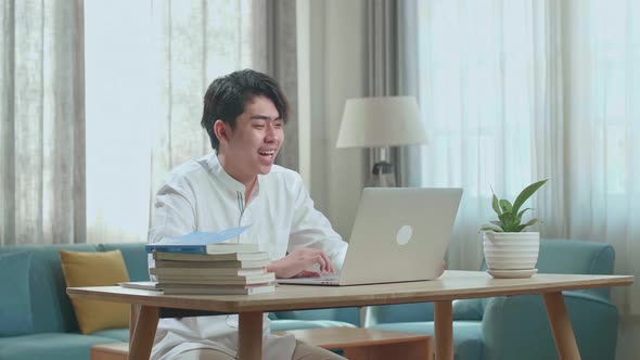 Asian Man Student Having Video Call While Using Computer To Study Online At Home