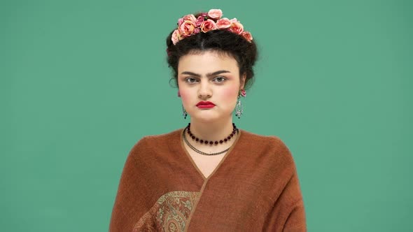 Fashion Portrait of Woman with Flowers in Hair As Frida Kahlo Posing on Camera with Playful Look and