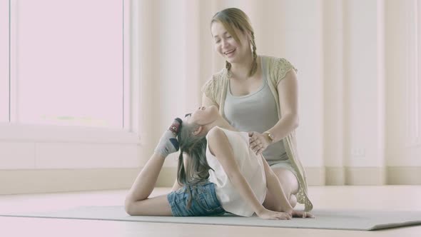 Asian mother and her daughter doing stretching exercise at home