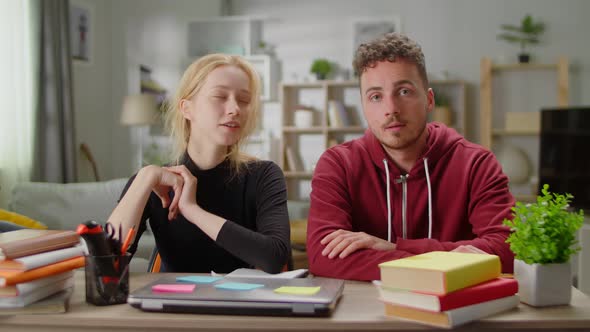 Young Man and Young Woman Together Blogging While Sitting at the Desk at Home in the Living Room