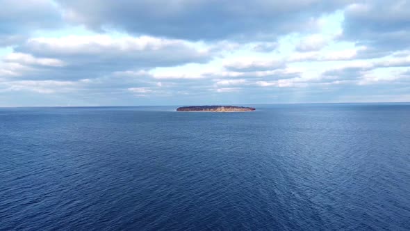 Aerial over a lake pushing towards an island day time.