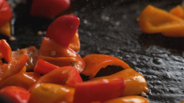 Stir frying orange and red bell pepper. Slow Motion.