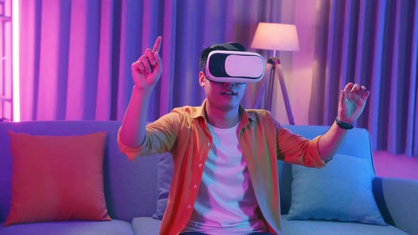 Young Asian Man Wearing Vr Headset At Living Room, Using Hand Touching And Slide