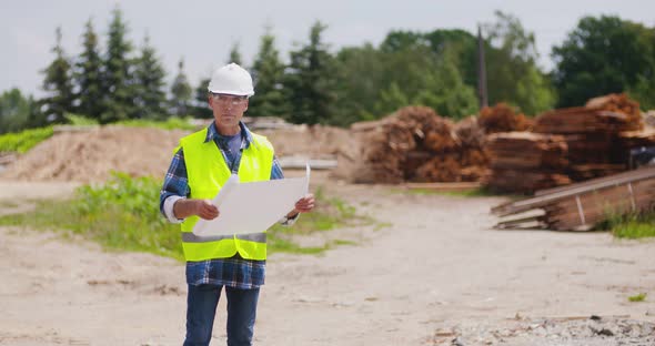 Male Engineer Explaining While Holding Blueprint