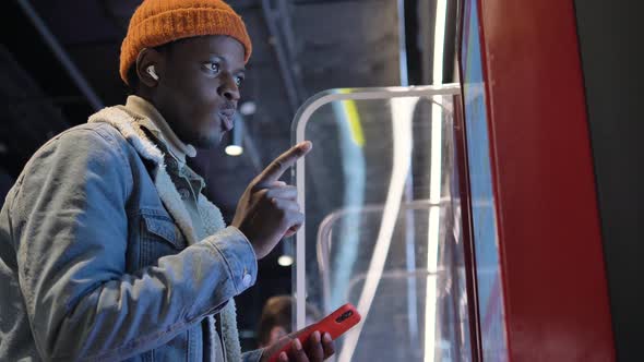 African Hipster Man Picks a Burger From the Electronic Selfservice Menu at a Fast Food Restaurant