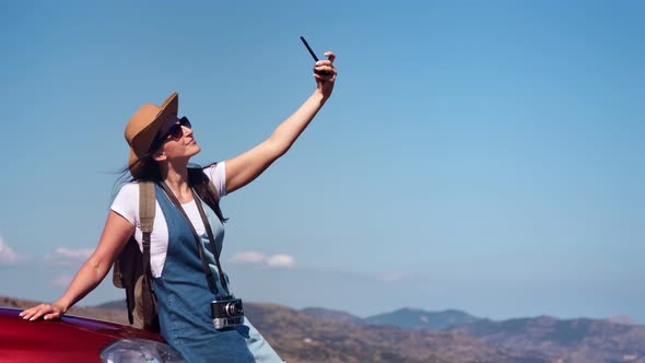 Adorable Positive Relaxed Tourist Female Taking Selfie on Automobile Using Smartphone