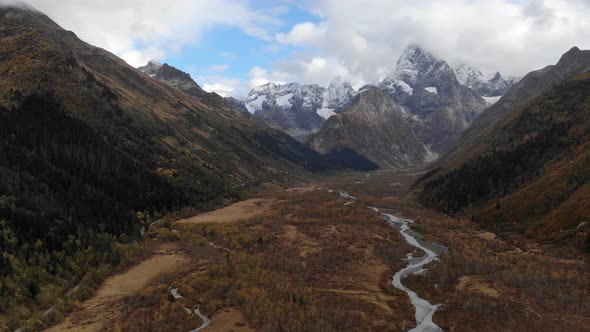 Autumn Mountain Valley with a River High in the Mountains with High Cliffs and Mountains and Epic