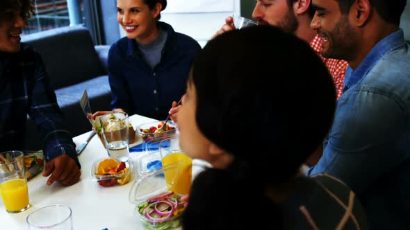 Happy executives interacting while having breakfast