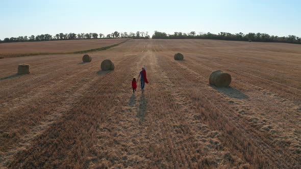 Aerial View of Dad and Son Running As Superheroes