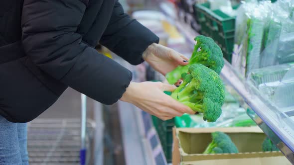 Woman Wearing Medical Mask to Prevent Covid19 Choosing Vegetables in a Supermarket