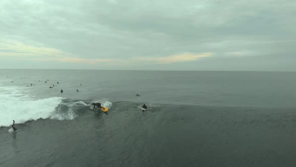 Aerial Shot of Pro Surfer riding big wave on a yellow board on a cloudy day in Pichilemu, Chile-4K