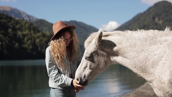 Woman Met a Wild Stallion on Vacation in the Mountains on a Lake Amazing View Turquoise Water High