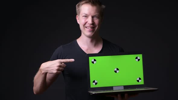 Young Handsome Man Using Laptop with Green Screen Chroma Key