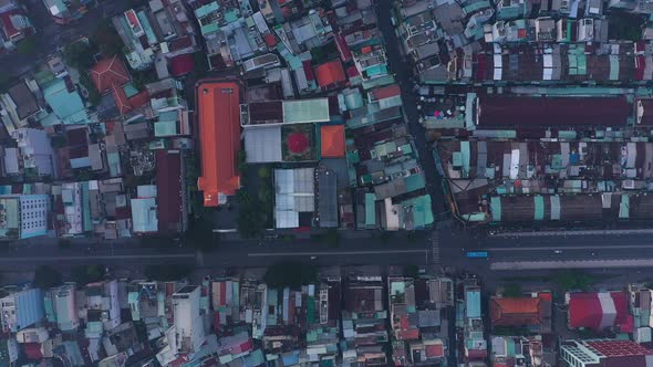 early morning top down drone view of street and rooftops in a busy and densely populated area featur