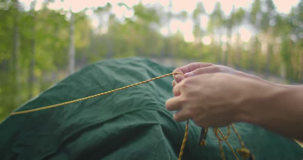 Portrait of a Man Setting Up a Tent in the Woods in Slow Motion