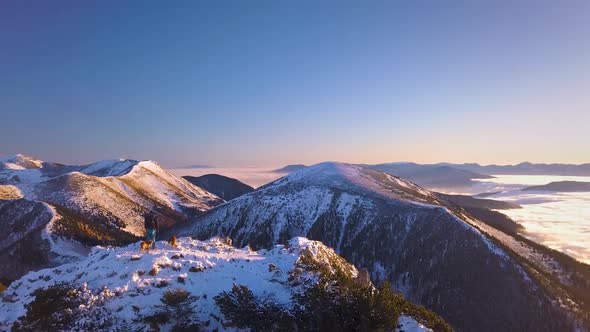 Blue Morning in Winter Alpine Mountain Snowy Nature at Colorful Sunrise with Foggy Clouds in Valley