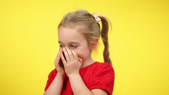 Closeup Portrait of Shy Little Blond Girl with Grey Eyes Talking Holding Hands on Mouth