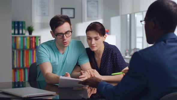 Young Couple Read Loan Contract Meeting with Bank Manager