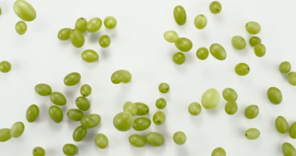 Green Fresh Grapes Flying Up to the Camera on a White Background in Slow Motion