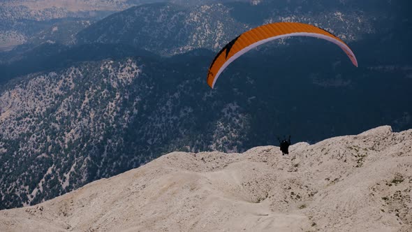 Paraglider Flies Against the Backdrop of Mountains