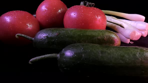 Fresh farm tomatoes, cucumbers and green onion leaves.