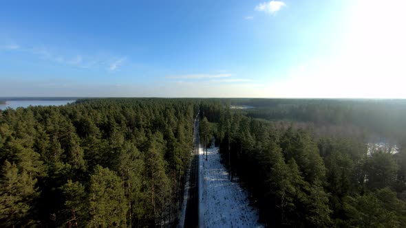 An aerial view of a road going through the forest during winter season, Poland.