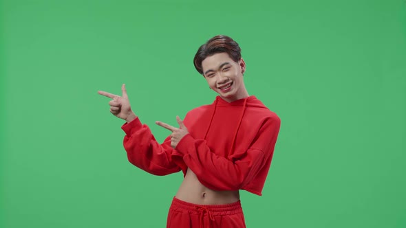 The Inspired Asian Transgender Male Smile And Pointing To The Side While Standing On Green Screen