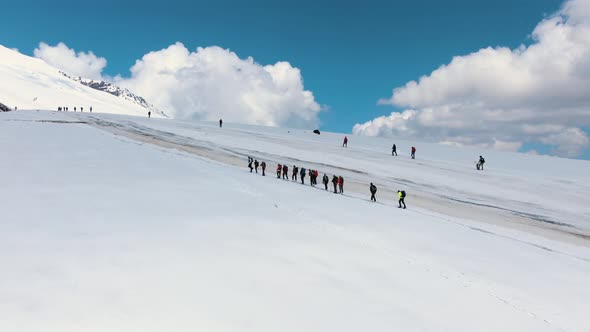 Group of People Climbs Snowy Mountains of Elbrus Along Road