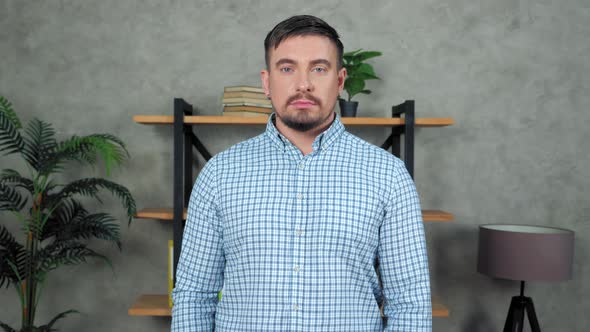 Portrait bearded businessman standing in modern office turns head looking camera