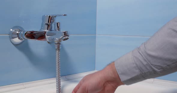 Man Is Switching Off Single Lever Mixer Tap in Bathroom, opening Plug , Hygiene Procedures