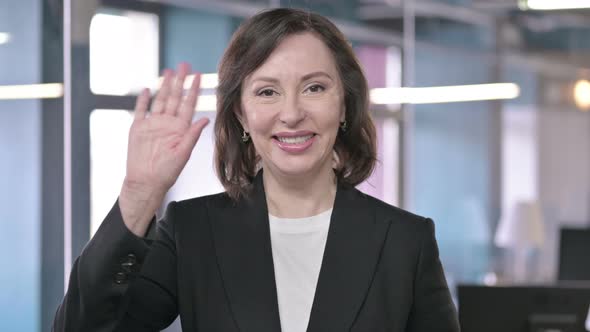 Portrait of Cheerful Middle Aged Businesswoman Waving at Camera