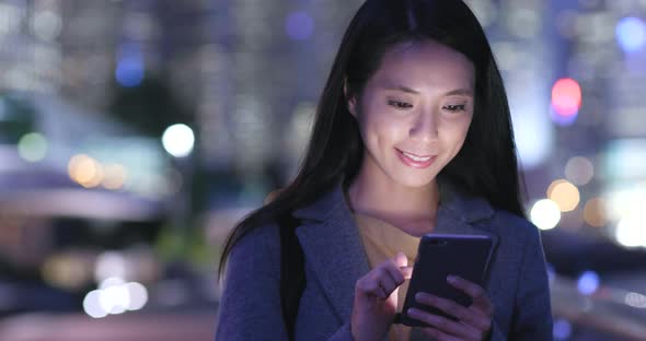 Woman use of mobile phone in Hong Kong at night