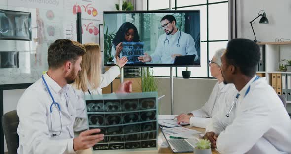 Multiethnic Doctors Sitting in front of Digital Screen During Online Meeting