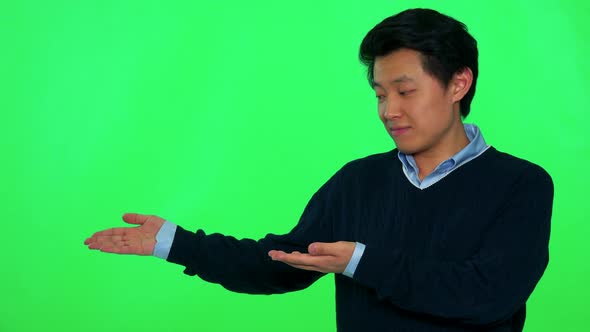 A Young Asian Man Presents Something - Green Screen Studio