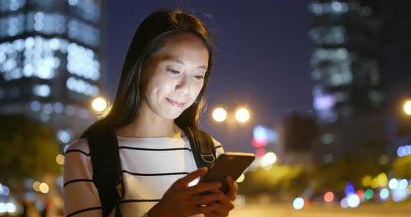 Woman use of mobile phone in city at night 