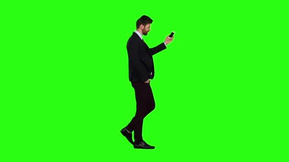 Guy Walks Down the Street, Puts His Hand in His Pocket and Talk Phone. Green Screen. Slow Motion