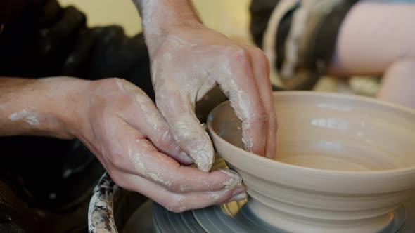 Close-up of Guy's Hands Making Bowl with Clay on Pottery Wheel in Workshop