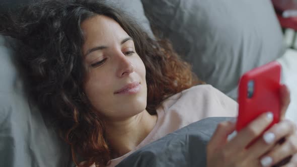 Pretty Woman Using Smartphone in Bed