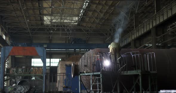 A Professional Welder Makes Steel Structures at the Factory