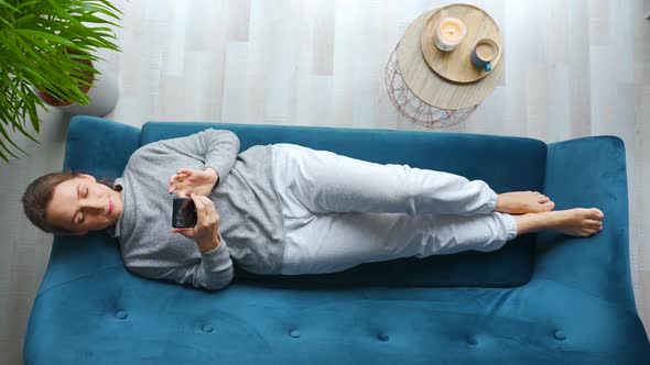 Overhead Shot of Happy Relaxed Woman Holding Smart Phone Using Mobile Apps Watching Funny Video