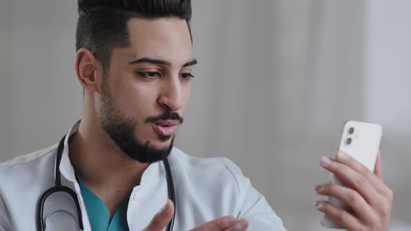 Confident Qualified Physician Male Arabian Doctor Use Smartphone Social Medical App Consult Clients