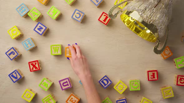 Woman Hand Arranging Wooden Cubes with Word WINNER Top View