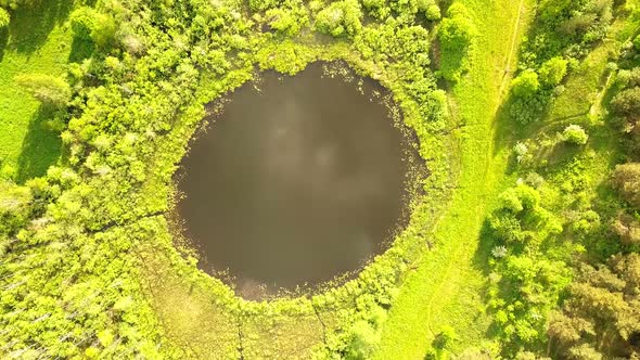 Aerial Flight From Top Bottom Over an Small Lake with Perfectly Round Shape