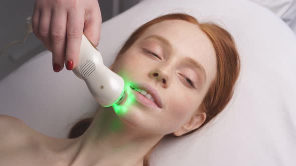 Portrait of a Woman on the Phonophoresis Device Facial Procedure in a Cosmetology Clinic