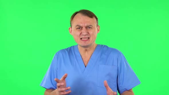 Medical Man Emotionally Looks at Something, Comments and Then Disappointedly Gives Up Hands. Green