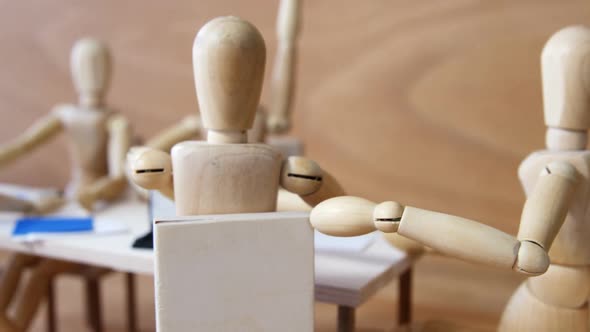 Wooden figurines having meeting in conference room