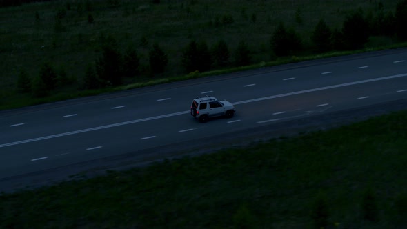 Aerial View of a Car on the Road in the Evening