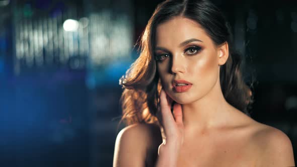 Beautiful Glamour Woman in Fashionable Dress Posing Over Blue and Red Lights Boker Background