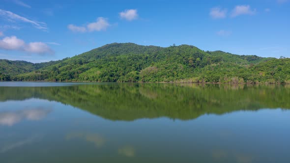 Beautiful reflection of clouds in water surface over lake or pond with Mountain tropical forest